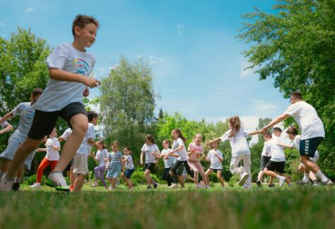 A group of children happily playing in a sunny park, enjoying outdoor activities and fun.